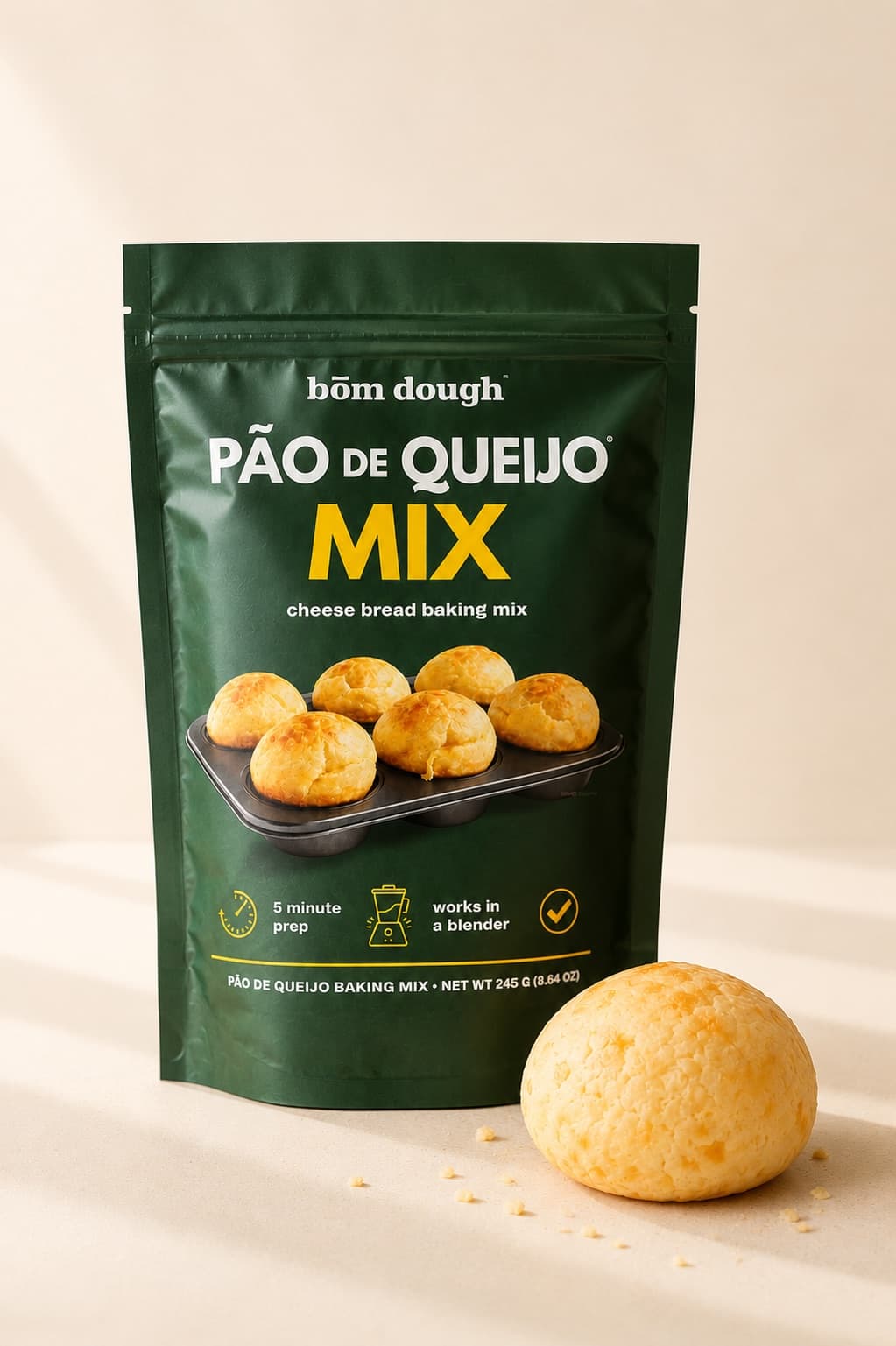 A bag of bōm dough Pão de Queijo Mix — gluten-free cheese bread baking mix — beside a freshly baked pão de queijo.
