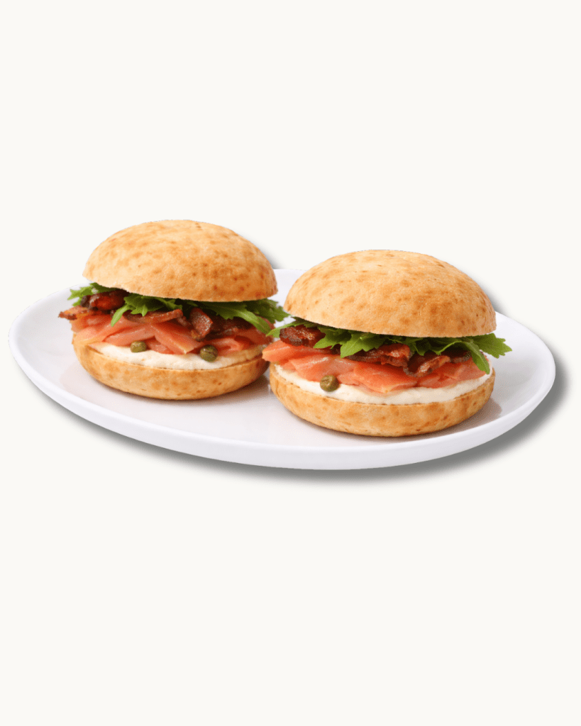 gluten-free luxe smoked salmon sandwich with capers and greens on a signature brazilian cheese bread bun.